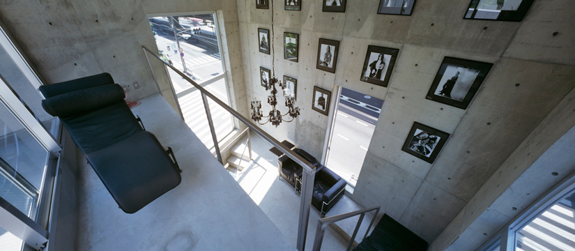 コンクリート壁に作品のかかるデザイナーのショップ兼アトリエ